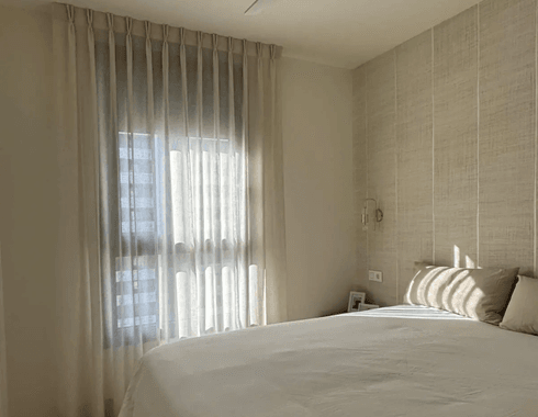 Cortinas de la colección Natur con confección a 2 nudos y riel blanco en dormitorio