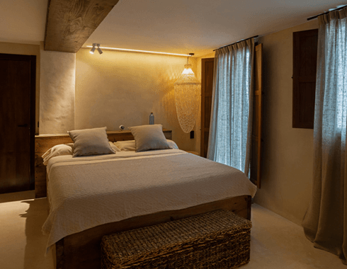 Proyecto real Etamin — dormitorio con cortinas de lino, madera y texturas naturales, luz cálida